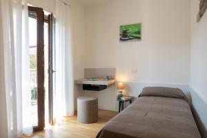 1 dormitorio con cama, mesa y ventana en Residence Mare Azzurro Sistiana, en Sistiana