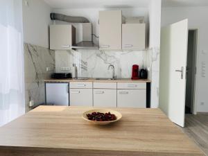 a kitchen with a bowl of fruit on a wooden table at IG-Apartments in Hattersheim