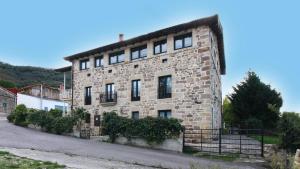 un gran edificio de ladrillo con ventanas en una calle en La Romanika de Fellini, en San Martín de Elines