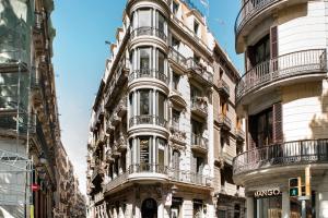 an apartment building with balconies on a city street at El Alma de las Ramblas in Barcelona