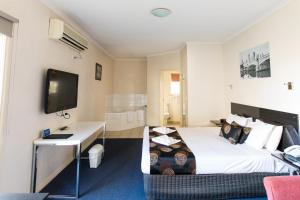 a hotel room with a bed and a television at Best Western Mill Park Motor Inn in Morang