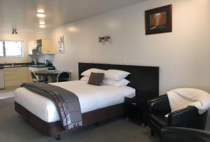 a hotel room with a bed and a kitchen at Colonial Manor Motel in Cromwell