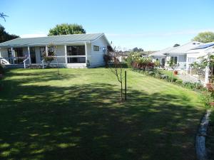 a house with a yard with a small tree in it at Cabourne Cottage in Hamilton
