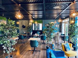 um restaurante com vasos de plantas, mesas e cadeiras em Sure Hotel by Best Western Calais Coquelles Tunnel s/ Manche em Coquelles
