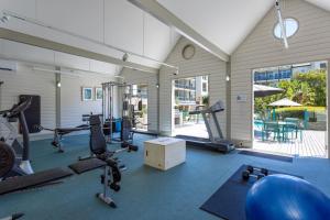 une salle de sport avec plusieurs tapis de course et vélos d'exercice dans l'établissement Portsea Village Resort, à Portsea