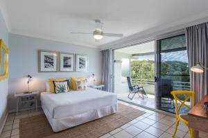 een slaapkamer met een wit bed en een balkon bij Poinciana Lodge - 2 bedroom - on Hamilton Island by HIHA in Hamilton Island