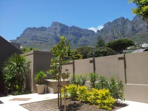 a garden with a fence with mountains in the background at One On Houghton in Cape Town