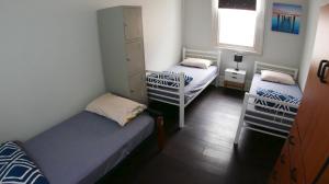 a bedroom with two twin beds and a window at Geraldton Backpackers in Geraldton