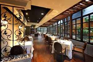 una sala da pranzo con tavoli, sedie e finestre di Taipei Garden Hotel - Ximending a Taipei