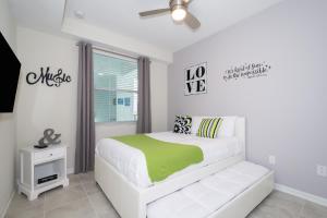 a white bedroom with a bed and a window at (HM207) Storey Lake Condo 2/2, Free Waterpark in Kissimmee