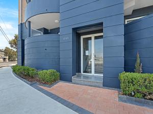 un edificio azul con una ventana en el lateral en Sydney Airport Suites, en Sídney