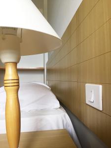 a lamp sitting on a table next to a bed at FLAT NO MELHOR DO RIO QUENTE 800m HOT PARK in Rio Quente