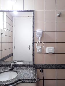 a bathroom with two sinks and a mirror at FLAT NO MELHOR DO RIO QUENTE 800m HOT PARK in Rio Quente
