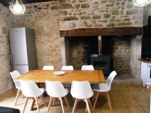 a dining room with a table and chairs and a fireplace at LOU CHASTEL, DEMEURE PERIGOURDINE CLIMATISEE avec PISCINE PRIVEE et CHAUFFEE in La Bachellerie
