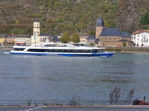 un gran barco en el agua frente a una ciudad en Ferienwohnung an der Fähre St. GOAR, en Sankt Goar