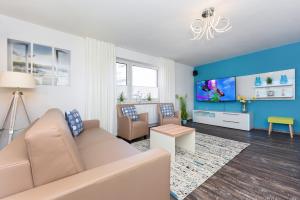 a living room with a couch and a tv at Haus zur Möwe mit Frühstücksoption in Bensersiel