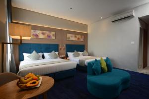 Blue Lotus Hotel في مدينة دافاو: غرفة فندقية بسريرين وطاولة وكرسي