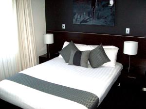 a bedroom with a large bed with pillows and avertisement at ibis Styles Broken Hill in Broken Hill