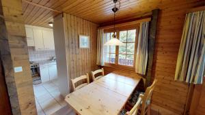 een eetkamer met een houten tafel en een keuken bij Susy in Blatten bei Naters