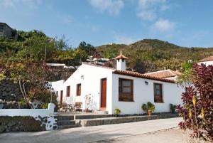 a white house with mountains in the background at Casa Rural La Furnia in Icod de los Vinos