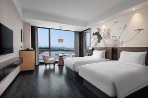 Postel nebo postele na pokoji v ubytování Fuzhou Mawei Yiho Hotel + 21 fotografií