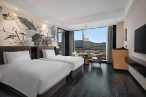 Postel nebo postele na pokoji v ubytování Fuzhou Mawei Yiho Hotel