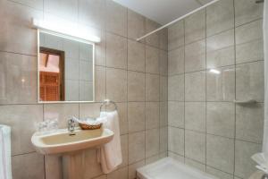 a bathroom with a sink and a mirror and a tub at Hotel Club Sunway Punta Prima in Es Pujols