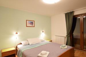 1 dormitorio con 1 cama con 2 toallas en Apartments Novak, en Rovinj