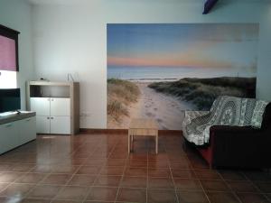 una sala de estar con una pintura de una playa en Ca la Valenta, en Sant Carles de la Ràpita