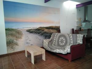 een woonkamer met een muurschildering van een strand bij Ca la Valenta in Sant Carles de la Ràpita