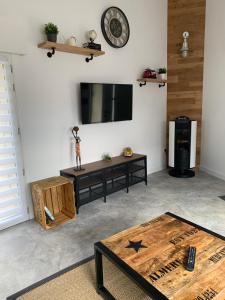 a living room with a tv and a table at ATELIER 85 in Les Épesses