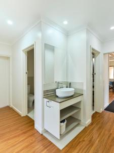 a white bathroom with a sink and a toilet at Skymirror Villa in Sea Lake