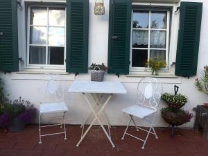 a table and two chairs in front of a house at Bed & Breakfast Chez Lips in Oberbildein