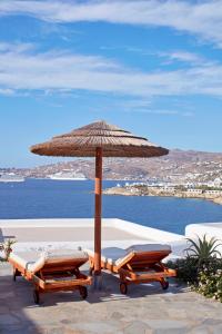 a row of wooden benches sitting on top of a beach at Grand Beach Hotel in Mikonos