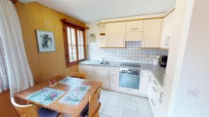 eine kleine Küche mit einem Holztisch und einem Waschbecken in der Unterkunft Guferli in Blatten bei Naters