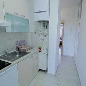 een witte keuken met een wastafel en een aanrecht bij Apartment Vali in Zagreb