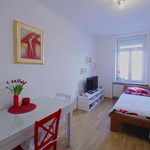 een slaapkamer met een tafel, een bed en een televisie bij Apartment Vali in Zagreb