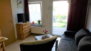 a living room with a couch and a tv at Bernstein Appartements in Dranske