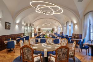 uma sala de jantar com uma mesa e cadeiras e um lustre em Hotel Štekl em Hluboká nad Vltavou