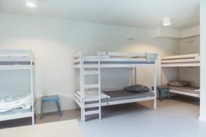 a room with three bunk beds in a room at Snuffel Youth Hostel in Bruges