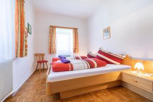 sypialnia z łóżkiem z kolorowymi poduszkami w obiekcie Landhaus Fingerhof w mieście Flachau