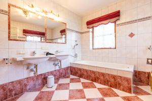 łazienka z wanną, umywalką i lustrem w obiekcie Landhaus Fingerhof w mieście Flachau +37 zdjęć