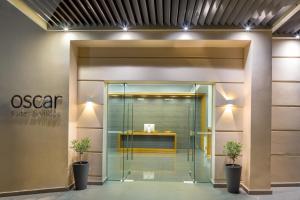 an office entrance with a glass door with two potted plants at Oscar Suites & Village in Agia Marina Nea Kydonias +104 photos