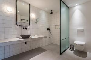 ein Badezimmer mit einem Waschbecken, einem WC und einem Spiegel in der Unterkunft Kin Athens in Athen