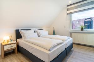 1 dormitorio con 2 camas y ventana en Strandfliederhaus en Norderney