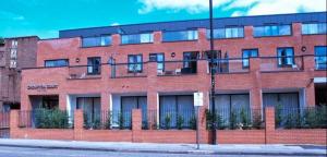 ロンドンにあるクロンプトン コート アパートメントの赤レンガ造りの通り窓付き