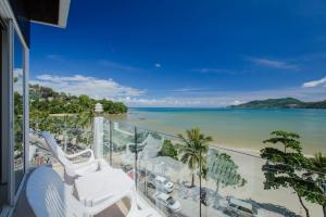 a balcony with chairs and a view of the beach at The Front Hotel and Apartments in Patong Beach
