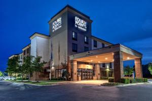 una vista frontal de un hotel con aparcamiento en Four Points Memphis Southwind, en Memphis