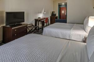 a hotel room with two beds and a flat screen tv at Four Points Memphis Southwind in Memphis
