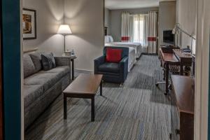 une chambre d'hôtel avec un canapé et un lit dans l'établissement Four Points Memphis Southwind, à Memphis